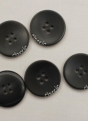 Пуговица пластик 4 прокола d-25мм черная с надписью - в интернет-магазине тканей Тессутидея арт. F-6663