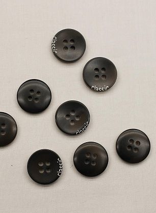 Пуговица пластик 4 прокола d-15мм черная с надписью - в интернет-магазине тканей Тессутидея арт. F-6666